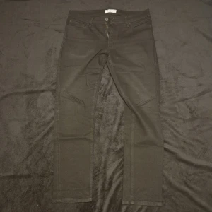 Svarta jeansbyxor - Snygga svarta jeansbyxor med en klassisk femficksdesign och knappgylf. Perfekta för en stilren look.