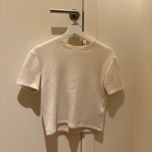 Vit kortärmad tröja - Stickad kortärmad tröja/t-shirt från Zara! Använd men i bra skick och inga tydliga defekter. Färgen är typ creme/vit