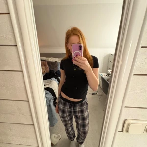 Rutig byxa med snörning - Säljer ett par bekväma rutiga byxor med snörning i midjan. Perfekta för en avslappnad stil. Byxorna har en elastisk midja och ett klassiskt rutmönster i svart och grått. Storleken är barnstorlek - 158/164 men passar mig som är 167cm