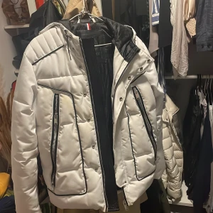 Vit quiltad jacka från Horspist - Snygg vit quiltad jacka från Horspist med svarta detaljer och dragkedjor. Jackan har en hög krage och långa ärmar, perfekt för kyligare dagar. Den har en stilren design med praktiska fickor och en bekväm passform. Jackan är köpt på trelupi men har ej kvar kvittot.