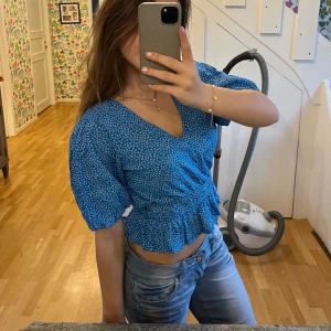 Blå blommig topp - söt blå blus med små vita blommor. Blusen har korta ärmar och en u-ringad design med snygga volangdetaljer nertill🩷 skriv gärna om ni har frågor❣️