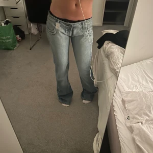 Blå bootcut jeans - Snygga blå bootcut jeans med låg midja och klassisk femfickdesign. De har en lätt tvättad look som ger en vintage känsla. Jag är ca 1,70 🥰🥰förstora för mig varav därför jag säljer!! osäker på storlek, står 32? jag brukar vanligtvis ha 36 