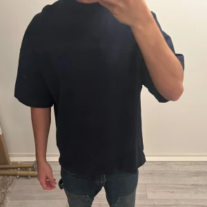Mörk blå oversize t-shirt från AMI - En väldigt färsch och unik T-shirt från AMI som kan vara perfekt för en fin sommar utekväll och kan stylas på olika sätt 