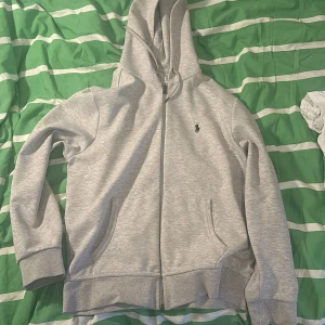 Grå hoodie från Ralph Lauren - Säljer nu min feta Ralph Lauren hoodie. Skick 9,5/10 endast använd ett fåtal gånger. Har en QR kod att skanna så man ser den är authentic. Flera frågor bara att skriva!