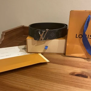 Svart bälte från Louis Vuitton - Svart LV bälte med det ikoniska blommiga mösntret. 115 cm långt. Kvitto och allt medföljer.