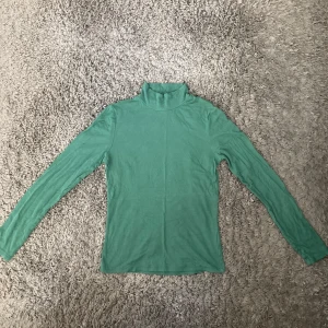 Grön långärmad halvpolo - Grön långärmad tröja med halvpolo i strl S. Tröjan är använd men är i gott skick. Skriv gärna angående eventuella frågor. :)