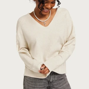 Beige v-ringad tröja - Säljer en stilren beige tröja med v-ringning. Tröjan har långa ärmar och en avslappnad passform, perfekt för en bekväm och trendig look. Aldrig använd. 