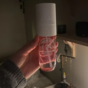 Parfymmist från Sol de Janeiro - Säljer en doftande parfymmist från Sol de Janeiro i en genomskinlig rosa flaska med vit kork. Perfekt för att fräscha upp dagen med en tropisk doft. Flaskan är stilren och lätt att ta med sig. Ungefär hälften kvar! Locket luktar lite skumt men inte något som påverkar innehållet 💓
