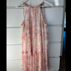 Mönstrad sommarklänning - Säljer en söt sommarklänning med ett färgglatt prickigt mönster i rosa och orange toner. Klänningen är ärmlös med smala axelband och har en luftig passform. Den är i bra skick då den är använd endast en gång🥰🥰
