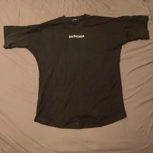 Svart t-shirt - Säljer en svart t-shirt med logotypen tryckt i vitt både fram och bak. T-shirten har en lite mer baggy passform med korta ärmar. Perfekt för en stilren look.