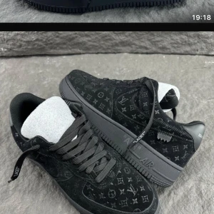 Svarta sneakers med monogrammönster - Snygga svarta sneakers med ett diskret monogrammönster. Skorna har en klassisk design med snörning och en robust sula. Perfekta för en stilren look.