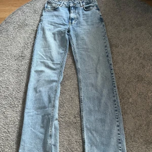 Blå jeans med midwaist - Storlek: waist 26, length 32. Fina blåa jeans med midwaist från Bikbok, fint skick. Hålet är design. Ordinarie pris 699kr men säljer för 400kr.Pris går att diskutera!