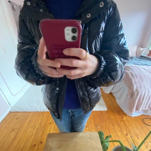 Snygg, svart vinterjacka - En superfin vinterjacka som glänser! Jackan är superskön och i bra material. Jackan har ingen luva, men heller inga defekter. Snygg, varm och bra passform. 🤍