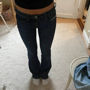 Mörkblå jeans med bootcut - Snygga mörkblå jeans med bootcut-stil och låg midja. Perfekta för en avslappnad look. Klassisk design med fem fickor och knappgylf. Köpta från diesel🤗jag är 174 som referens 