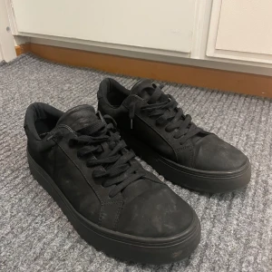 Svarta sneakers från Vagabond - Snygga svarta sneakers från Vagabond i mocka med klassisk snörning. Perfekta för en stilren look med en robust sula. Nästan helt nya då bara använt fåtal gånger. Storlek 43/44
