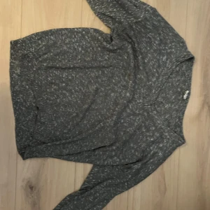 Grå stickad tröja - Säljer en mysig grå stickad tröja med långärmad design. Perfekt för kyligare dagar med sin mjuka och bekväma passform. Tröjan har en klassisk look som passar till det mesta. Hör av dig vid intresse!