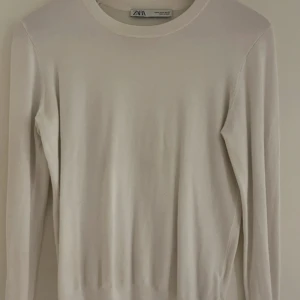 Vit tröja från Zara med knappar - Säljer en vit tröja från Zara i storlek M. Tröjan har guld/rose knappar vid ärmen längst ner som en fin detalj. 