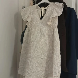 Vit klänning med volang - Superfin vit klänning med volanger och öppen i ryggen. Köpt här på plick, men säljer vidare då den va för stor på mig. Passar perfekt till studenten eller bara under sommaren💗🤩 (Lånade bilder, skriv för egna bilder)