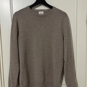 Beige kashmirtröja från John Henric - Säljer en stilren beige kashmirtröja från John Henric. Tröjan har en klassisk rund halsringning och långa ärmar. Perfekt för att hålla sig varm och snygg under kyligare dagar. Passar bra till både jeans och chinos.      Har ett hål på baksidan av tröjan som inte syns lika tydligt när du har på dig tröjan.                                             Ny pris 2200kr.       Pris kan diskuteras 