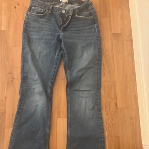 Blå jeans från Young Gina - Säljer ett par  blå jeans med en bekväm passform. Byxorna har en knapp och en dragkedja nertill. De har justering band där man själv justera passformen runt midjan. Barnstorlek 164/170