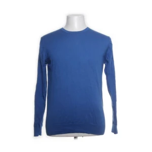 Blå tröja från Riley - Snygg blå tröja från Riley i 100% bomull. Perfekt för en stilren look med sin enkla design och långa ärmar. Tillverkad av mjuk Pima Cotton för extra komfort.