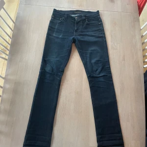 Mörkblå jeansbyxor - Snygga mörkblå jeansbyxor med en klassisk femficksdesign och knappgylf. Perfekta för en stilren look. De har en slim passform som ger en modern siluett.