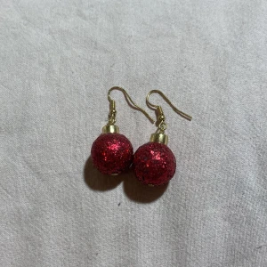 Glittriga röda örhängen - Snygga örhängen med glittriga röda julkulor och guldfärgade krokar. 