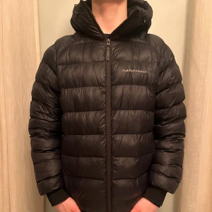 Peak Performance Vinterjacka - Säljer en marinblå dunjacka från Peak Performance. Storleken är Medium: Han på bilden är 177cm och väger 67Kg. Skriv vid funderingar👍Nypris 3199kr