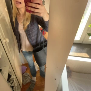 Blå/grå quiltad jacka - Säljer en snygg blå/grå quiltad jacka med knappar. Jackan har en normal passform och är perfekt för vår och höst. Den är långärmad och har en stilren design som passar till det mesta. Perfekt för dig som vill ha en lätt och bekväm jacka.