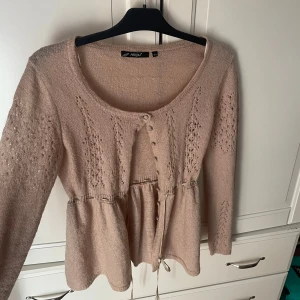 Beige stickad kofta med band - Säljer en söt beige stickad kofta köpt från en marknad utomlands. Koftan har ett knytband i midjan för en fin passform 💕💕