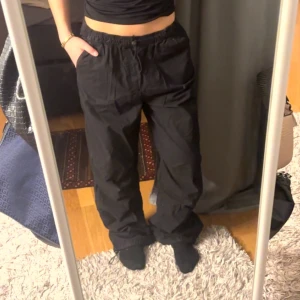 Svarta byxor med resårmidja - Snygga svarta byxor med loose passform och resår i midjan. Perfekta för en avslappnad stil. Byxorna har en enkel design utan extra detaljer.