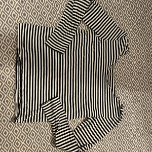 Svartvit randig långärmad topp - Randig topp i ungefär storlek M. Bra skick och inga tydliga defekter förutom att den är klippt uppe vid nacken. KÖP ENDAST VIA POSTNORD