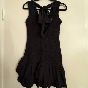 Svart ärmlös klänning med volang - Jättefin klänning från Zara med volang och rosett i ryggen! Aldrig använd och har lappen kvar 
