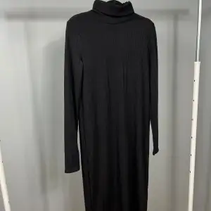 Snygg svart ribbad klänning från Zara med polokrage och långa ärmar. Perfekt för en stilren look. Klänningen är i en bekväm passform och passar bra till kyligare dagar.