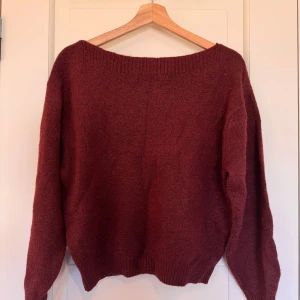 Vinröd stickad tröja - Mysig vinröd stickad tröja med långa ärmar och ribbstickade muddar. Perfekt för kyliga dagar.