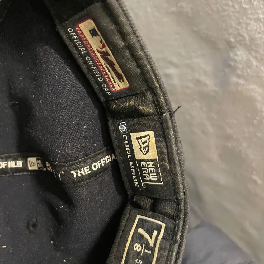 Snygg svart keps från New Era med broderad vit logga på framsidan. Kepsen har en klassisk design och är perfekt för sportiga tillfällen. Tillverkad i ett slitstarkt material med en bekväm passform. Den är äkta . Asusteet.