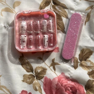 Nagelkit - Sött nagelkit med lösnaglar. Kommer i en praktisk rosa förvaringsask. Inkluderar en rosa nagelfil för enkel applicering och formning . Perfekt för speciella tillfällen.