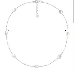 Halsband med pärlor - Elegant halsband med en tunn silverkedja och jämnt fördelade vita pärlor. Perfekt för att ge en subtil och sofistikerad touch till din outfit. Justerbar längd med ett enkelt lås.