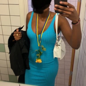 Turkos ribbad klänning - Snygg turkos ribbad klänning med ärmlös design. Passar perfekt till sommaren. Klänningen har även en slits som man kan se på sista bilden. Den sitter jäte fint och har en jäte fin färg!💘