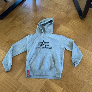 Grå hoodie från Alpha Industries - Säljer en snygg och bekväm grå hoodie från Alpha industries. Den är i bra skick. 