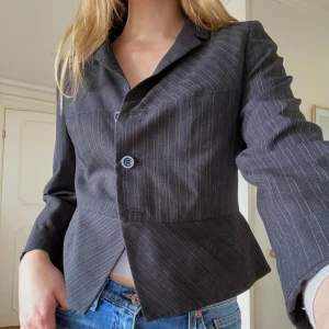 Randig kavaj - Randig kavaj med axelvaddar. I storlek 42 men mer som storlek 38/40. Skriv privat för frågor eller flera bilder. Bredd 51 cm Längd 53 cm