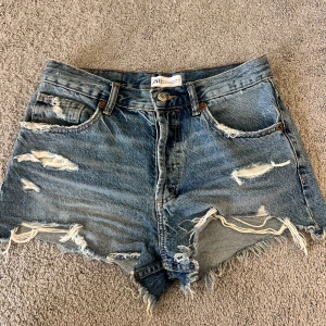 Slitna jeansshorts - Jeansshorts från Zara med slitningar. 
