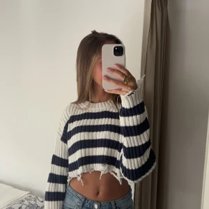 Randig croppad tröja från Zara - Säljer en superfin randig tröja från Zara i storlek S. Den är vit och blå med ett coolt croppat snitt och ribbad design. Passar superbra både till jeans och kjol. Tröjan har används några gånger men är i mycket bra skick. 