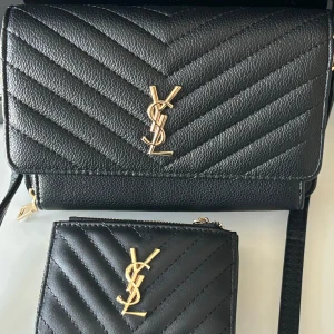 Väsk set med plånbok - Säljer denna YSL väska och plånbok, ej äkta. Bra skick aldrig använda. Går att köpa plånbok eller väska separat! 