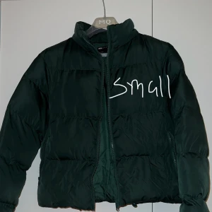 Mörkgrön pufferjacka från ASOS - Säljer en snygg mörkgrön pufferjacka från ASOS i storlek small. Jackan har en dragkedja framtill och är perfekt för kyliga dagar. Den är både stilren och bekväm, idealisk för höst och vinter. Passar perfekt för en casual look!