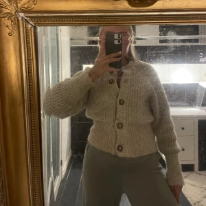 Beige kofta - En mysig stickad kofta i beige. Storlek S. Den går in lite i midjan och blir något ”figursydd.”