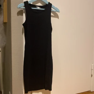 Svart ärmlös klänning - Snygg svart ärmlös klänning i en tight passform.Säljer den för den blev för liten.skriv för fler bilder!!