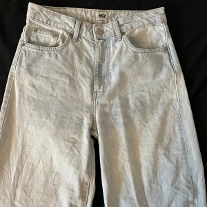 Ljusblå jeans från 157 - Säljer ett par ljusblå jeans från lager 157 i bra skick. De har en klassisk femficksdesign och är tillverkade i denim. Perfekta för vardagsbruk och kan matchas med nästan vad som helst. Passformen skulle jag beskriva som baggy och straight leg och de har en knappgylf. Perfekta för både vår och sommar! Storlek M!