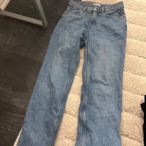 Blå jeansbyxor Gina tricot. - Säljer ett par klassiska blå jeansbyxor i bra skick. De har en normal passform och är perfekta för vardagsbruk. Byxorna har en knapp och dragkedja framtill samt fickor både fram och bak. Perfekta för både höst och vår!