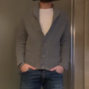 Filippa K cardigan - Säljer en stilren grå kofta från Filippa K i herrstorlek S. Den är ribbad och har stora knappar framtill. Perfekt för höst och vinter!Superbekväm och i mycket bra skick! Skriv vid frågor!!